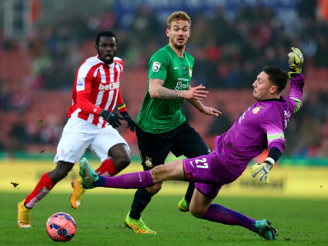 Blaine Hudson and Jonathan Flatt of Wrexham attempt to clear the ball during the FA Cup Third Round match between Stoke City and Wrexham at Britannia Stadium on January 4, 2015
