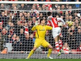 Arsenal's French defender Laurent Koscielny heads the opening goal past Stoke City's Bosnian goalkeeper Asmir Begovic during the English Premier League football match between Arsenal and Stoke City at the Emirates Stadium in London on January 11, 2015