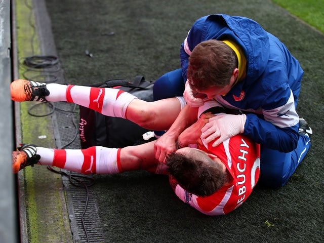 Mathieu Debuchy of Arsenal receives treatment for an injury before being stretchered off during the Barclays Premier League match between Arsenal and Stoke City at Emirates Stadium on January 11, 2015
