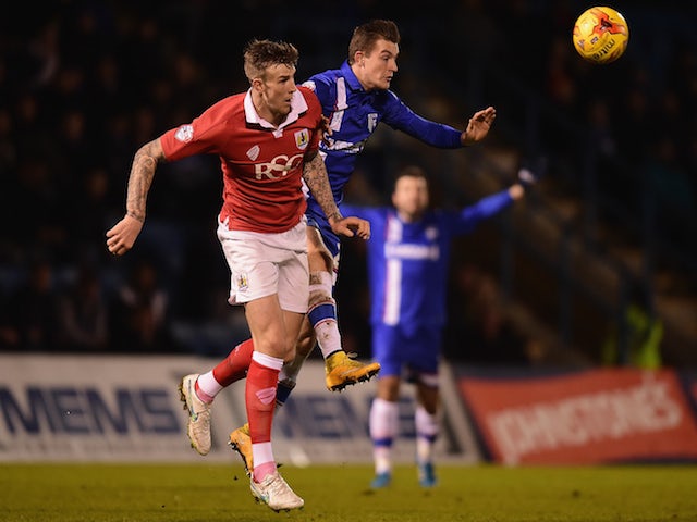 Brennan Dickenson of Gillingham battles with Aden Flint of Bristol City during the Johnstone's Paint Southern Area Final first leg, on January 6, 2015