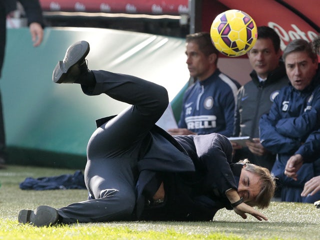 Inter Milan coach Roberto Mancini is struck by a ball during the Italian Serie A football match Inter Milan vs Genoa on January 11, 2015