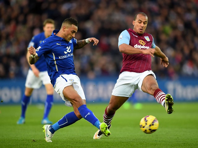 Danny Simpson of Leicester City passes the ball as Gabriel Agbonlahor of Aston Villa closes in during the Barclays Premier League match between Leicester City and Aston Villa at The King Power Stadium on January 10, 2015