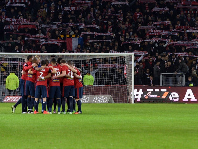 Evian's and Lille's players stand in circles as they observe a minute of silence for the victims of an attack at the Paris headquarters of satirical weekly Charlie Hebdo, which killed at least 12 and injured many, prior to the French L1 football match bet