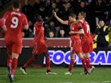 Steven Gerrard of Liverpool is congratulated by teammates Mamadou Sakho and Jordan Henderson after scoring his team's second goal from a free kick during the FA Cup Third Round match between AFC Wimbledon and Liverpool at The Cherry Red Records Stadium on