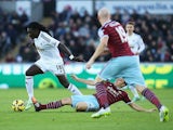 Bafetibis Gomis of Swansea City is tackled by Mark Noble of West Ham United during the Barclays Premier League match between Swansea City and West Ham United at Liberty Stadium on January 10, 2015