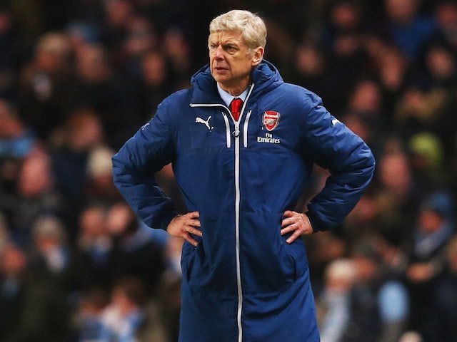 Arsenal manager Arsene Wenger stands with hands on hips while wearing his ridiculous coat on January 18, 2015