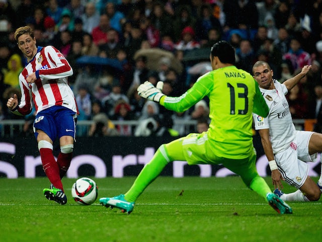 Fernando Torres (L) of Atletico de Madrid scores their second goal across Real Madrid goalkeeper Keylor Navas (2ndL) and his teammate Pepe (R) during the Copa del Rey Round of 16 match on January 15, 2015