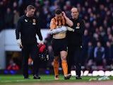 An injured James Chester of Hull City is assisted from the pitch during the Barclays Premier League match against West Ham United on January 18, 2015