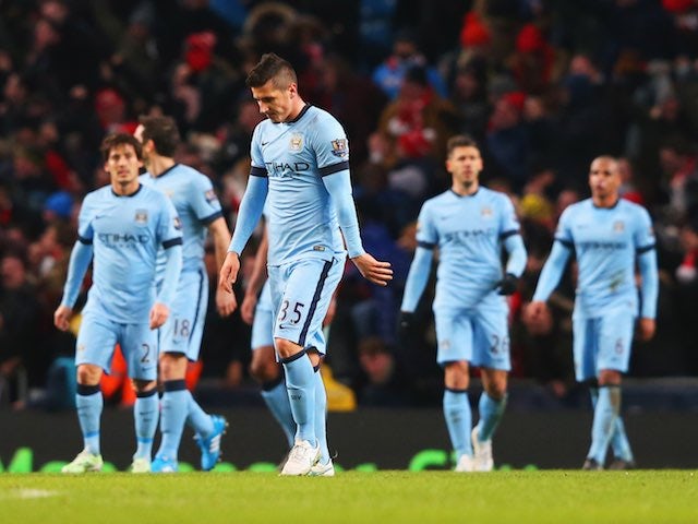 An assortment of Manchester City players look downbeat after Arsenal score their second on January 18, 2015