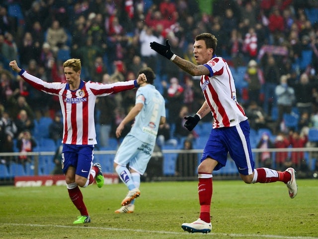 Atletico Madrid's Mario Mandzukic and Fernando Torres celebrate after scoring during the Spanish League football match against FC Granada on January 18, 2015
