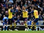 Theo Walcott of Arsenal celebrates with team-mates Aaron Ramsey and Mathieu Flamini after scoring the opening goal during the FA Cup Fourth Round match between Brighton & Hove Albion and Arsenal at Amex Stadium on January 25, 2015