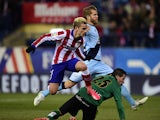 Atletico Madrid's French forward Antoine Griezmann jumps over Rayo Vallecano's goalkeeper Tono Rodriguez after scoring during the Spanish League football match Atletico de Madrid vs Rayo Vallecano at Vicente Calderon stadium in Madrid on January 24, 2015