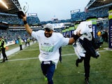 Russell Wilson #3 of the Seattle Seahawks holds up the George S. Halas trophy after the Seahawks 28-22 overtime victory against the Green Bay Packers on January 18, 2015