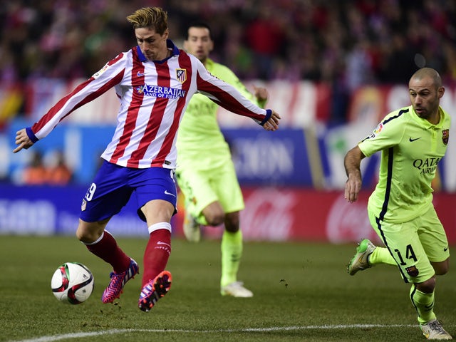 Atletico Madrid's forward Fernando Torres shoots to score past Barcelona's Argentinian midfielder Javier Mascherano during the Spanish Copa del Rey (King's Cup) quarter final second leg football match Club Atletico de Madrid vs FC Barcelona at the Vicente