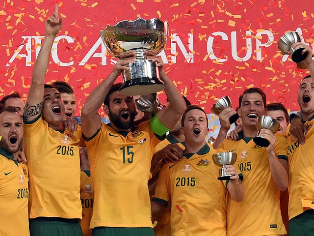 Australia's captain Mile Jedinak holds up the AFC Asian Cup football trophy after beating South Korea at Stadium Australia in Sydney on January 31, 2015