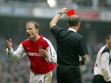 Arsenal's Dennis Bergkamp (L) argues with referee Mike Riley after being sent off for stamping on Liverpool's Jamie Carragher (R) 27 January 2002