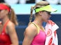 Eugenie Bouchard of Canada wipes her face as Maria Sharapova of Russia looks on in her quarterfinal match during day nine of the 2015 Australian Open at Melbourne Park on January 27, 2015