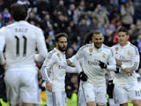 Real Madrid's French forward Karim Benzema celebrates with teammates after scoring during the Spanish league football match Real Madrid CF vs Real Sociedad de Futbol at the Santiago Bernabeu stadium in Madrid on January 31, 2015