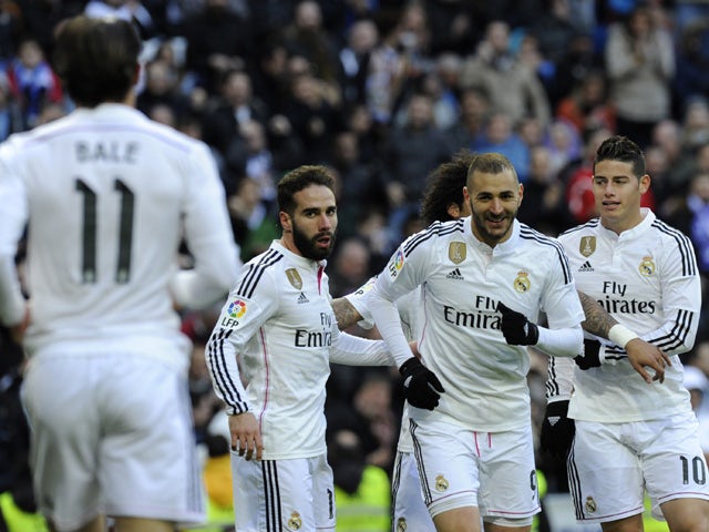 Real Madrid's French forward Karim Benzema celebrates with teammates after scoring during the Spanish league football match Real Madrid CF vs Real Sociedad de Futbol at the Santiago Bernabeu stadium in Madrid on January 31, 2015