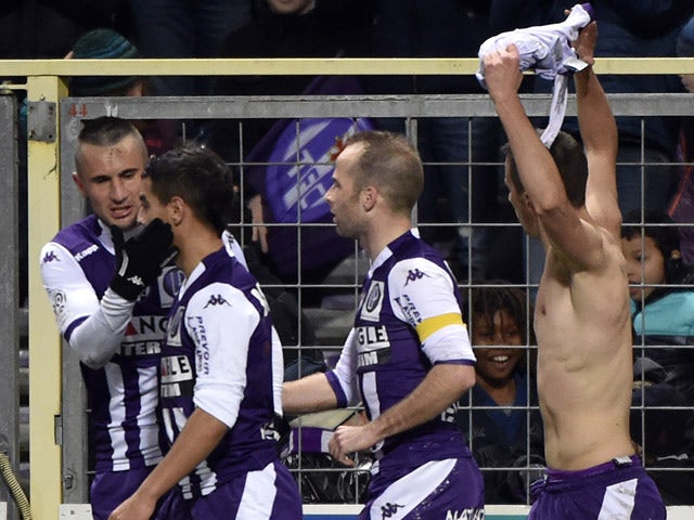 Toulouse's Serbian forward Aleksandar Pesic holds up his jersey as he celebrates with teammates after scoring during the French L1 football match Toulouse against Reims on January 31, 2015 