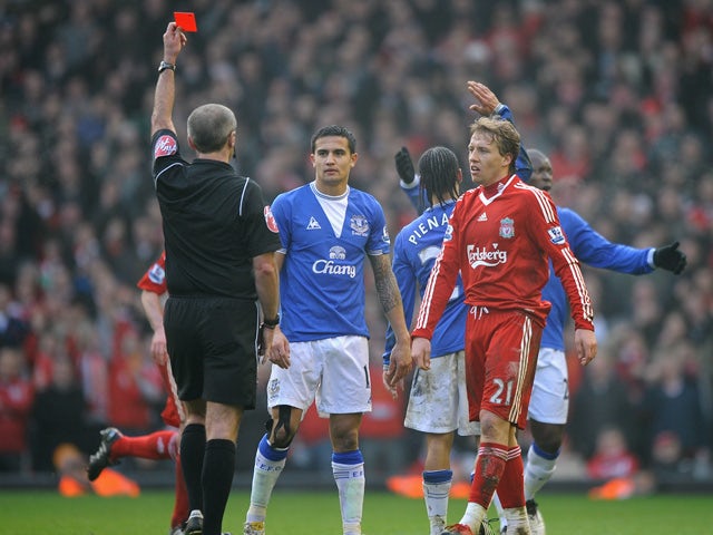 Referee Martin Atkinson shows a red card to Steven Pienaar of Everton during the Barclays Premier League match between Liverpool and Everton at Anfield on February 6, 2010