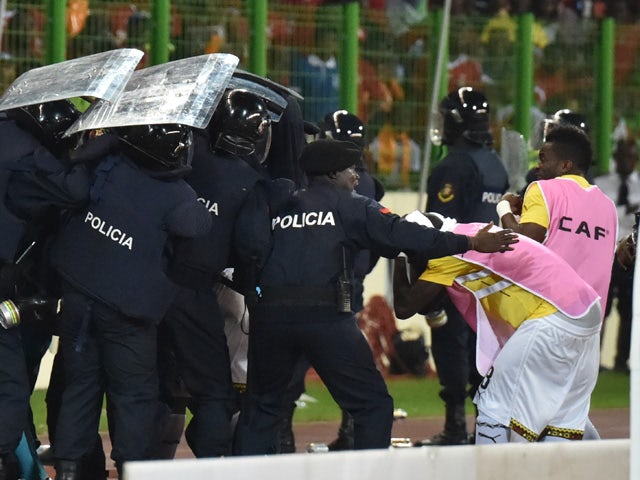 Ghana's national football team players leave the pitch protected by riot police at the half-time of the 2015 African Cup of Nations semi-final football match between Equatorial Guinea and Ghana in Malabo, on February 5, 2015