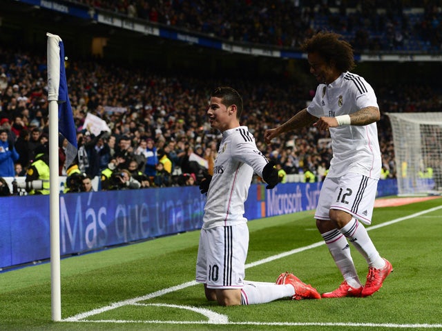Real Madrid's Colombian midfielder James Rodriguez celebrates past Real Madrid's Brazilian defender Marcelo after scoring during the Spanish league football match Real Madrid CF vs Sevilla FC at the Santiago Bernabeu stadium in Madrid on February 4, 2015