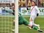 Roma's forward from Serbia Adem Ljajic scores against Cagliari's goalkeeper Zeljko Brkic during the Italian Serie A football match between Cagliari and AS Roma on February 8, 2015