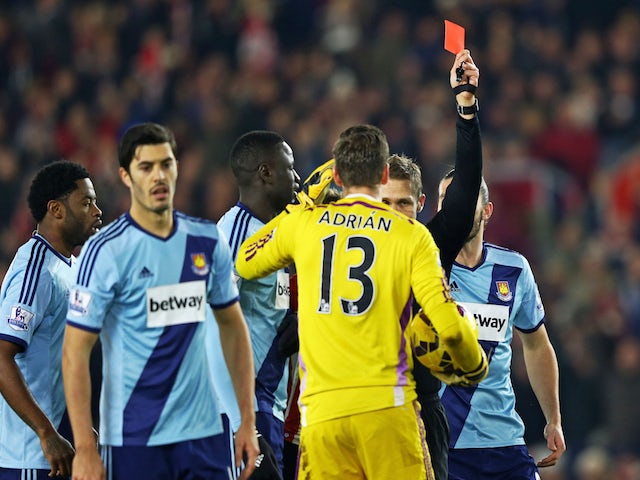 Adrian of West Ham receives a red card from referee Craig Pawson after diving on the ball outside of the area ahead of Sadio Mane of Southampton during the Premier League match on February 11, 2015