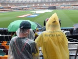 Spectators wearing rain gear wait in the stands as rain from Cyclone Marcia delays the start of the 2015 Cricket World Cup match between Australia and Bangladesh at the Gabba cricket stadium in Brisbane on February 21, 2015