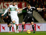 Lomban (L) of Elche competes for the ball with Karim Benzema of Real Madrid during the La Liga match on February 22, 2015