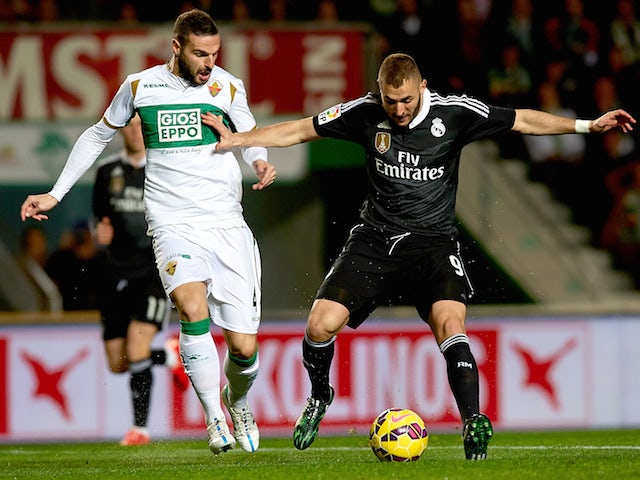 Lomban (L) of Elche competes for the ball with Karim Benzema of Real Madrid during the La Liga match on February 22, 2015