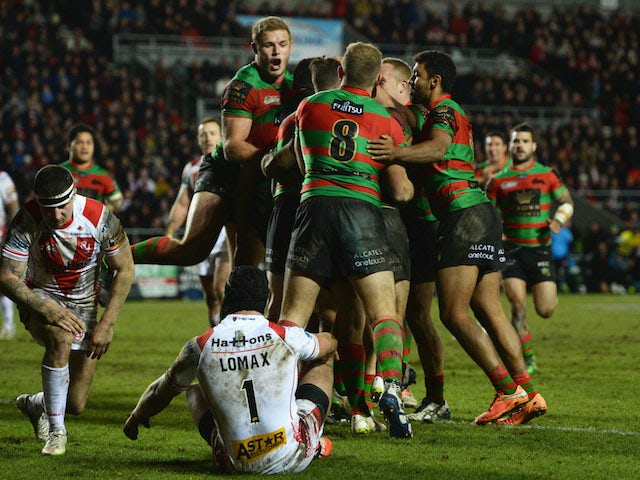 Luke Keary of South Sydney Rabbitohs (obscured) is mobbed by team mates after scoring their fifth tryduring the World Club Challenge match against St Helens on February 22, 2015