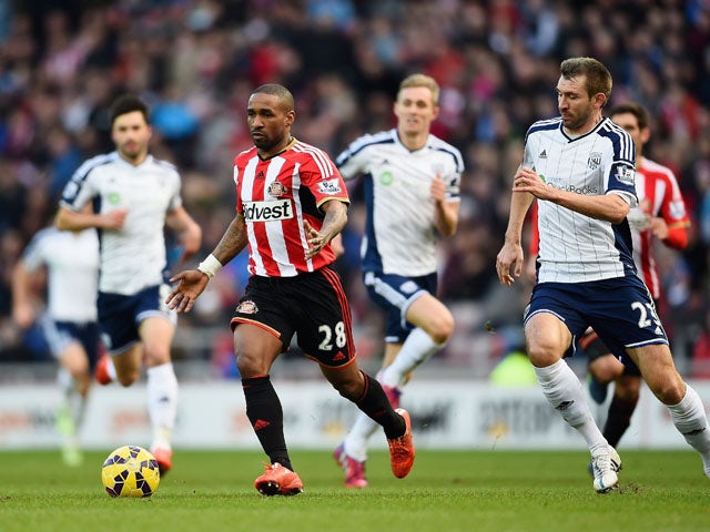 Jermain Defoe of Sunderland is callenged by Gareth McAuley of West Brom during the Barclays Premier League match between Sunderland and West Bromwich Albion at Stadium of Light on February 21, 2015