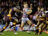 George Williams of Wigan Warriors gets past Sam Thaiday of Brisbane Broncos during the World Club Series match between Wigan Warriors and Brisbane Broncos at DW Stadium on February 21, 2015