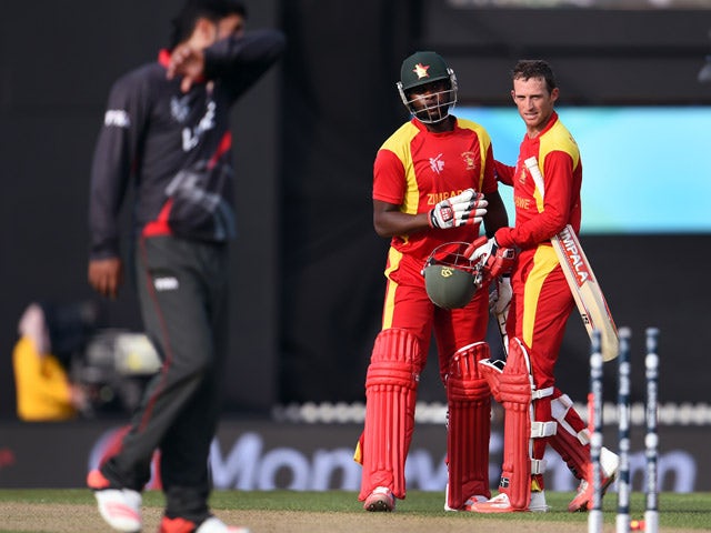 Zimbabwe batsmen Sean Williams and Elton Chigumbura celebrate victory as United Arab Emirates (UAE) player Mohammad Naveed reacts during their Pool B 2015 Cricket World Cup match in Nelson on February 19, 2015