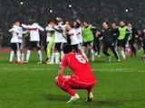 Liverpool's Dejan Lovren reacts after missing the last penalty while Besiktas' players celebrate during the UEFA Europa League round of 32 second-leg football match Besiktas  on February 26, 2015