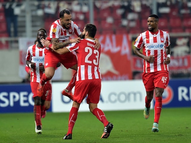 Olympiacos' forward Kostas Mitroglou (L) celebrates with teammates after scoring a goal during the UEFA Europa League Round of 32 football match Olympiacos vs Dnipro in Athens on February 26, 2015