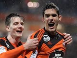 Lorient's French defender Francois Bellugou celebrates with a teammate after scoring a goal during the French L1 football match between Lorient and Bastia on February 27, 2015