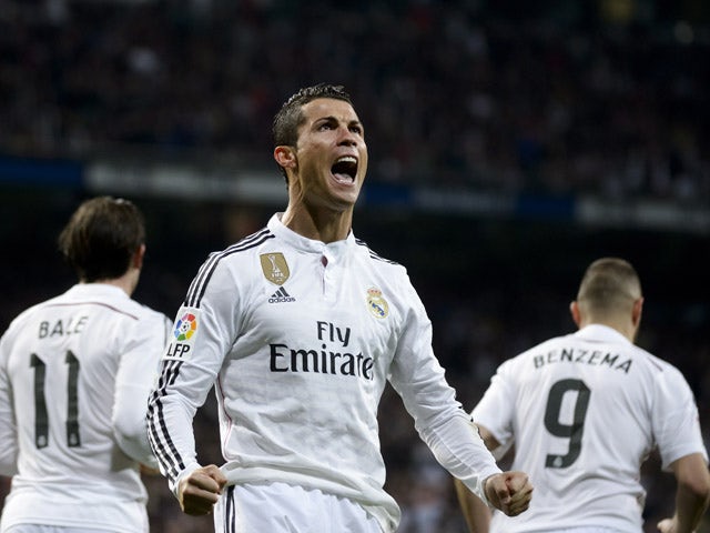 Real Madrid's Portuguese forward Cristiano Ronaldo celebrates after scoring on a penalty kick during the Spanish league football match Real Madrid CF vs Villarreal CF at the Santiago Bernabeu stadium in Madrid on March 1, 2015