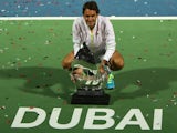 Roger Federer of Switzerland poses with the ATP Dubai Duty Free Tennis Championships trophy after defeating World number one Novak Djokovic of Serbia during their final on February 28, 2015