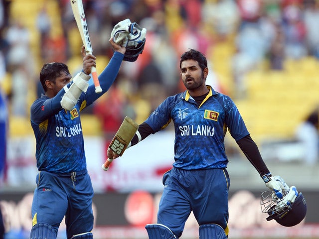 Sri Lanka batsmen Kumar Sangakkara and Lahiru Thirimanne wave to fans after hitting the winning runs against England during their 2015 Cricket World Cup Group A match in Wellington on March 1, 2015
