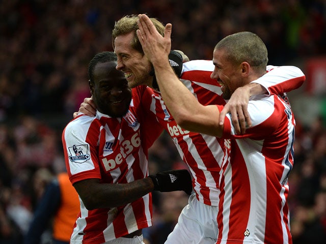 Peter Crouch of Stoke City celebrates scoring the first goal with team-mates Victor Moses and Jonathan Walters during the Barclays Premier League match between Stoke City and Hull City at Britannia Stadium on February 28, 2015