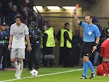 Atletico Madrid's Portuguese midfielder Tiago (L) is given the red card from Czech referee Pavel Kralovec during the UEFA Champions League first-leg, round of 16 football match against Bayer 04 Leverkusen on February 25, 2015