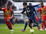 Paris Saint-Germain's French midfielder Adrien Rabiot (C) advances with the ball past Lens' French defender Loick Landre (L) during the French L1 football match  on March 7, 2015