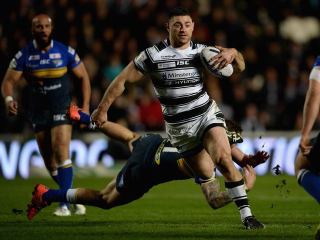 Mark Minichiello of Hull FC jumps from a tackle from Adam Cuthbertson of Leeds Rhinos during the First Utility Super League match between Hull FC and Leeds Rhinos at KC Stadium on March 5, 2015