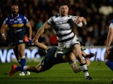 Mark Minichiello of Hull FC jumps from a tackle from Adam Cuthbertson of Leeds Rhinos during the First Utility Super League match between Hull FC and Leeds Rhinos at KC Stadium on March 5, 2015