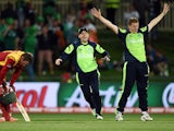 Ireland cricketer Nial O'Brien runs in to congratulate brother and teammate Kevin O'Brien after he took the wicket of Zimbabwe batsman Sean Williams (L) at the Bellerive Oval ground during the 2015 Cricket World Cup Pool B match between Ireland and Zimbab