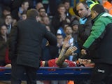 Liverpool's Slovakian defender Martin Skrtel talks with Liverpool's Northern Irish manager Brendan Rodgers as he is carried off the pitch on a stretcher during FA Cup quarter-final match between Liverpool and Blackburn Rovers at Anfield in Liverpool, nort