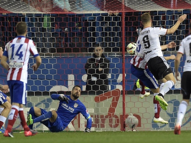 Valencia's German defender Shkodran Mustafi (R) heads a ball and scores during the Spanish league football match against Atletico Madrid on March 8, 2015